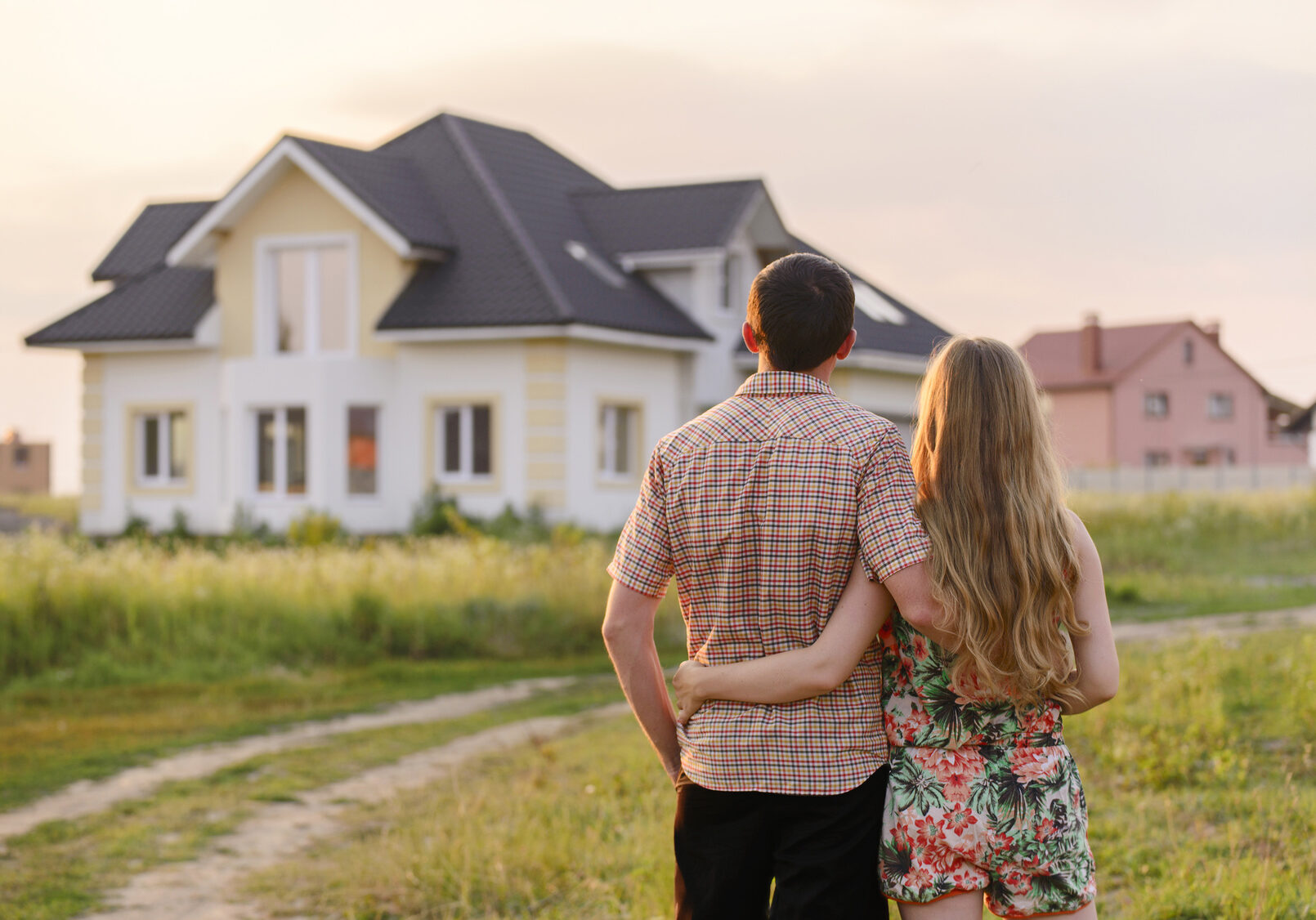 rear view of young couple looking at their new house